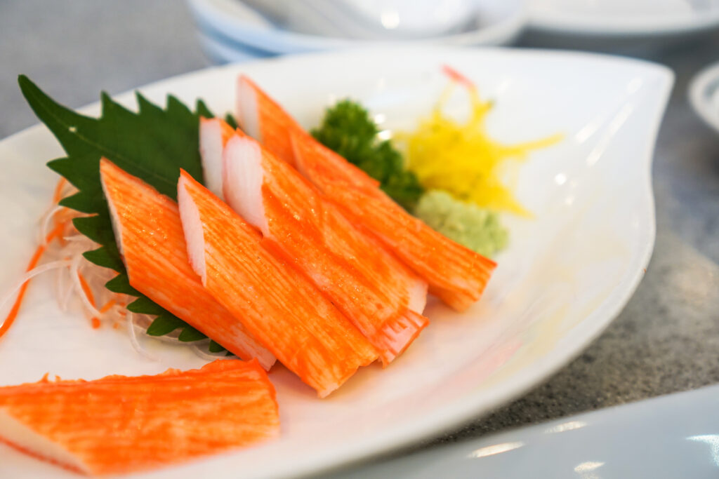 crab sticks in a white dishl placed on a table.